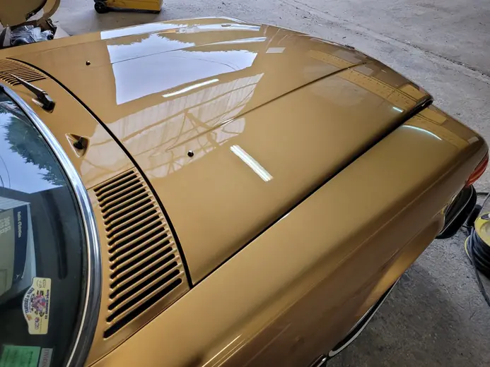 Mercedes 450 SL dorée en cabine de peinture