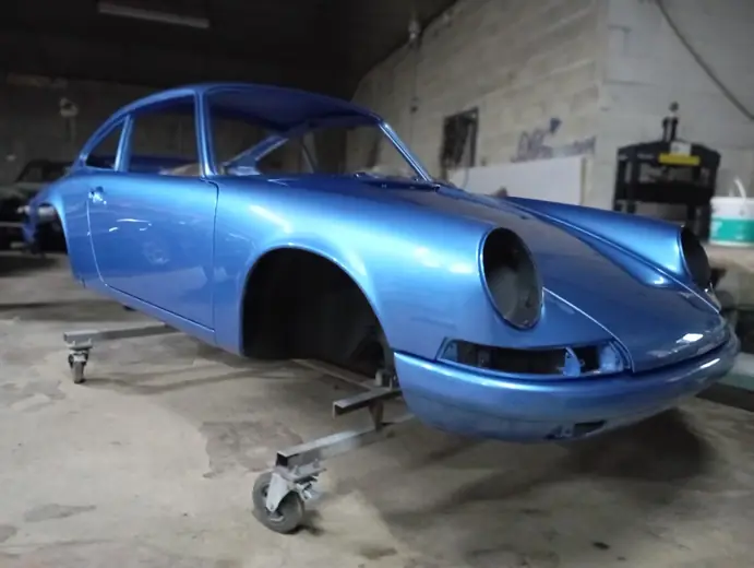 Porsche 911 bleue en cabine après peinture